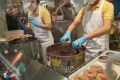 クリスピー・クリーム・ドーナツのチョコレートグレーズド作業 クリスピー・クリーム・ドーナツのチョコレートグレーズド作業